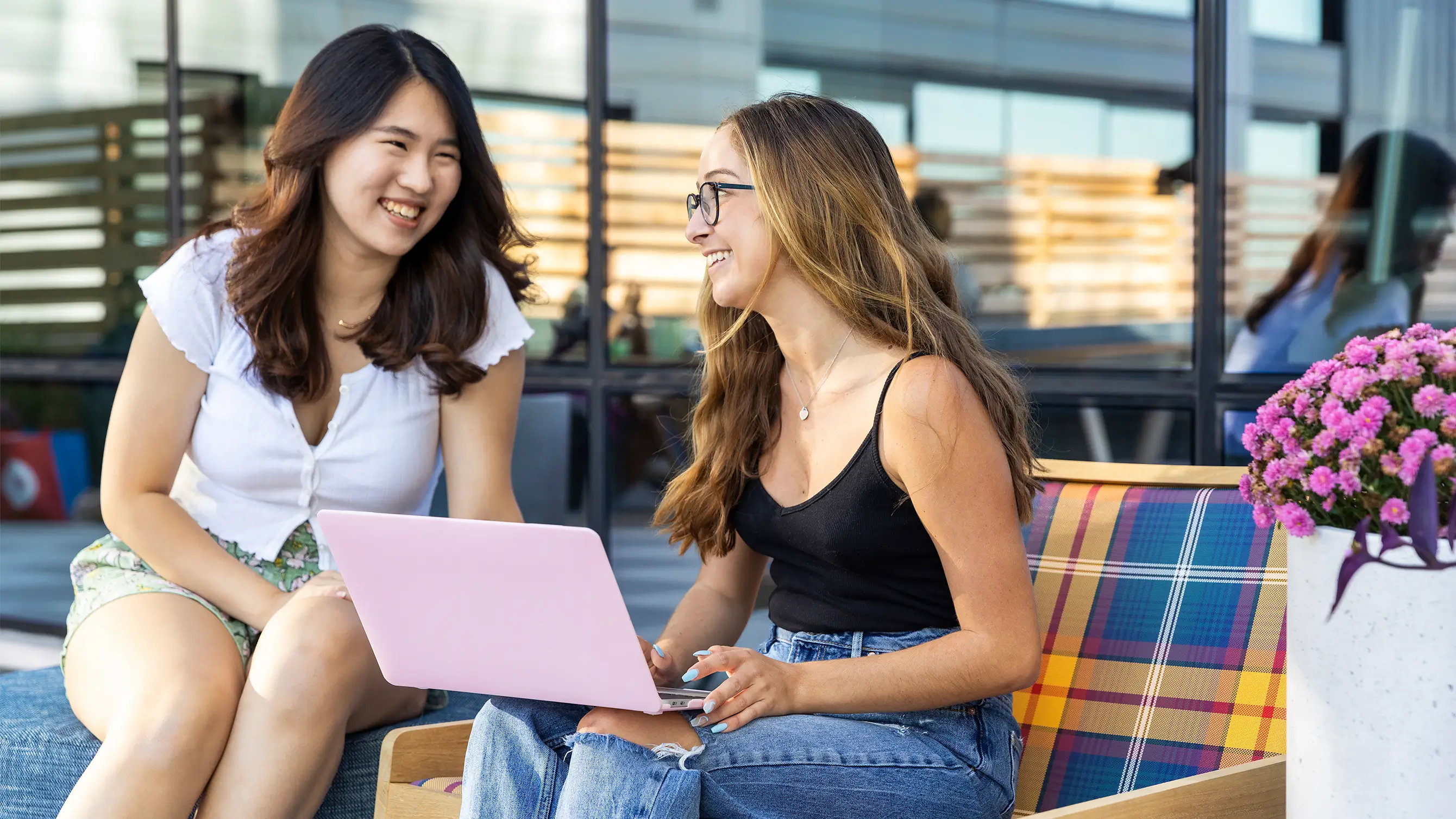 two friends using a laptop